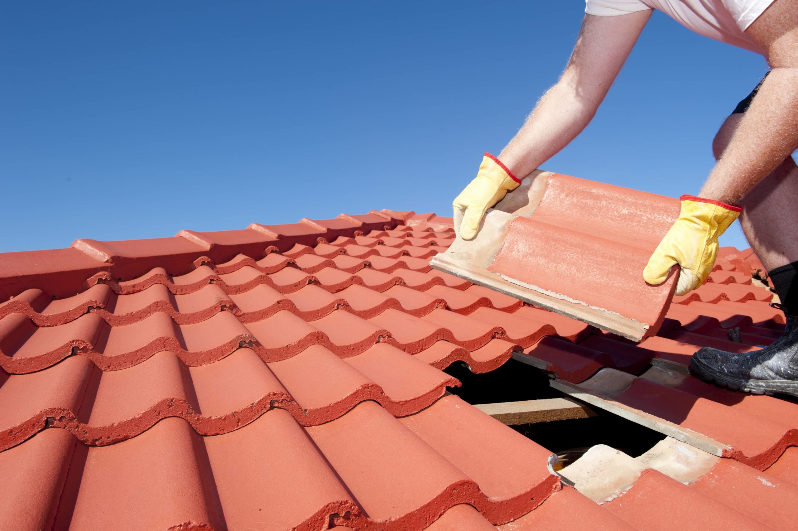 This is an image of a contractor repairing a roofing and replacing a roof shingle.